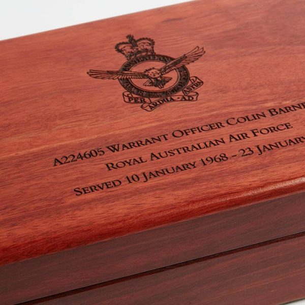 Close up of wooden lid on large medal box, showing personalised military engraving.