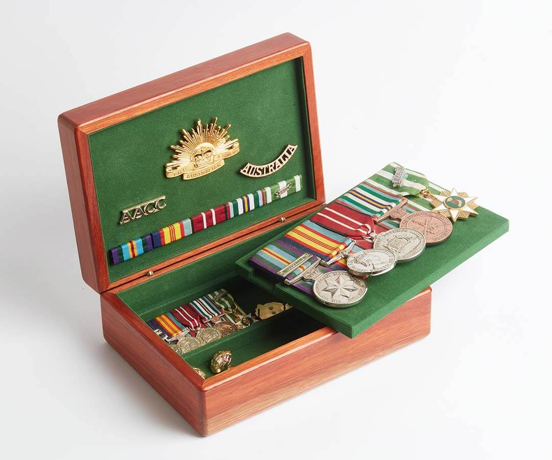 A wooden medal box by Murphy's of Healesville, opened up to show a display of military veteran medals.