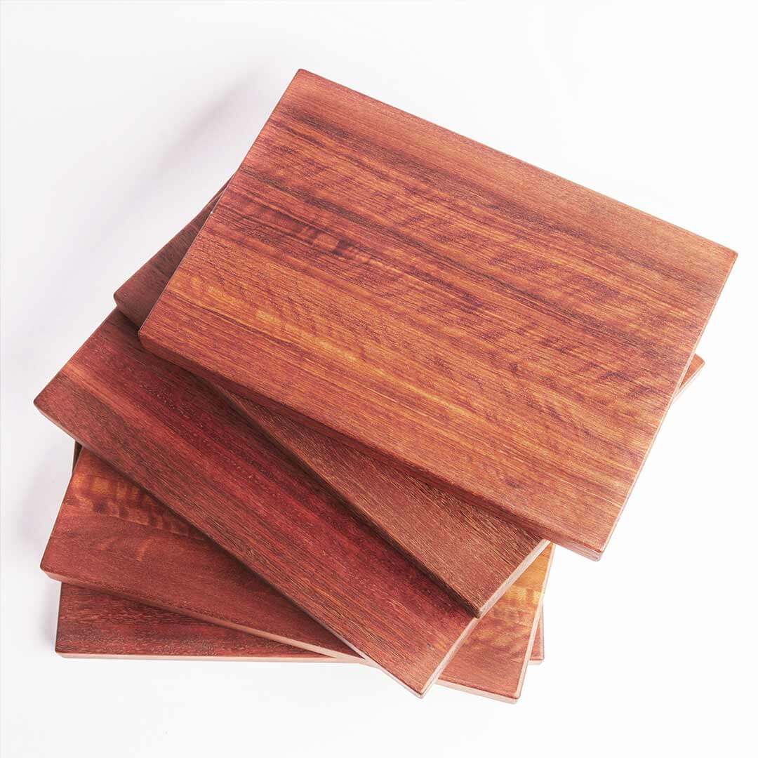 Stack of jarrah wooden cheese boards, showing range of colours.